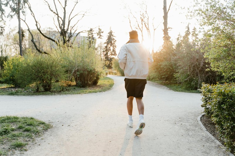 Runner on a park path at sunset